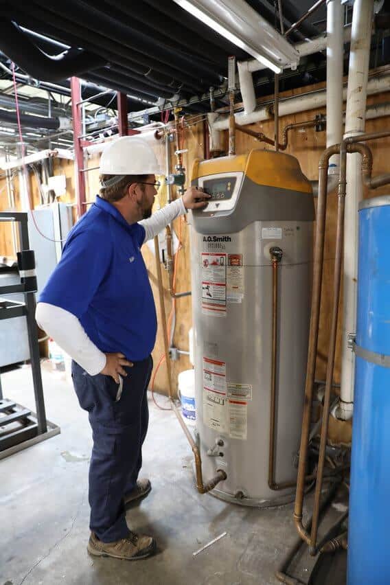 Technician performing maintenance on a commercial water heater