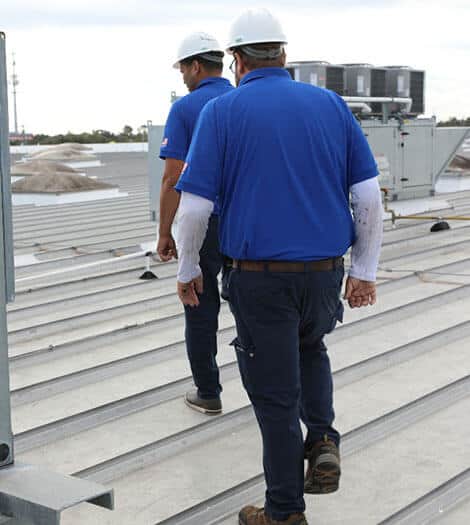 Technicians walking on roof of commercial building
