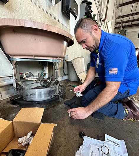 Technician performing a commercial plumbing repair.