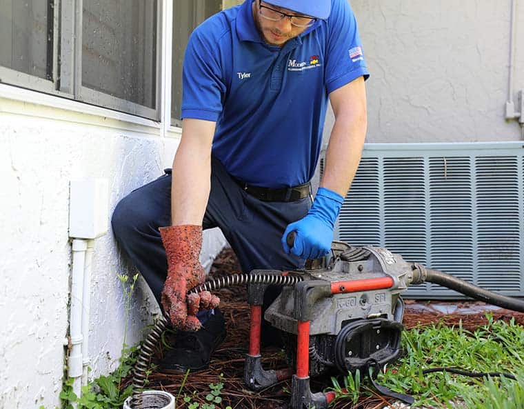 plumber using a heavy-duty sewer drain cleaning machine