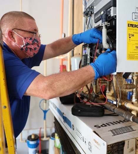 technician performing maintenance on water heater